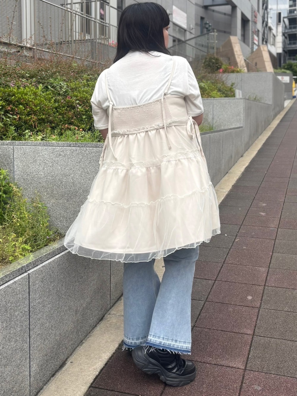 ホワイト系のワンピース、ブルー系のデニムパンツ、ホワイト系のTシャツ/カットソーを着用したレディースの春コーディネートの3枚目の写真