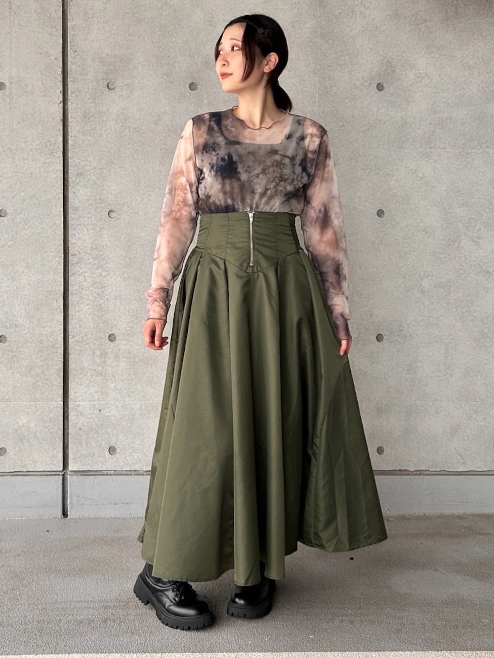 グリーン系のスカート、ブラウン系のTシャツ/カットソーを着用したレディースの夏コーディネートの3枚目の写真