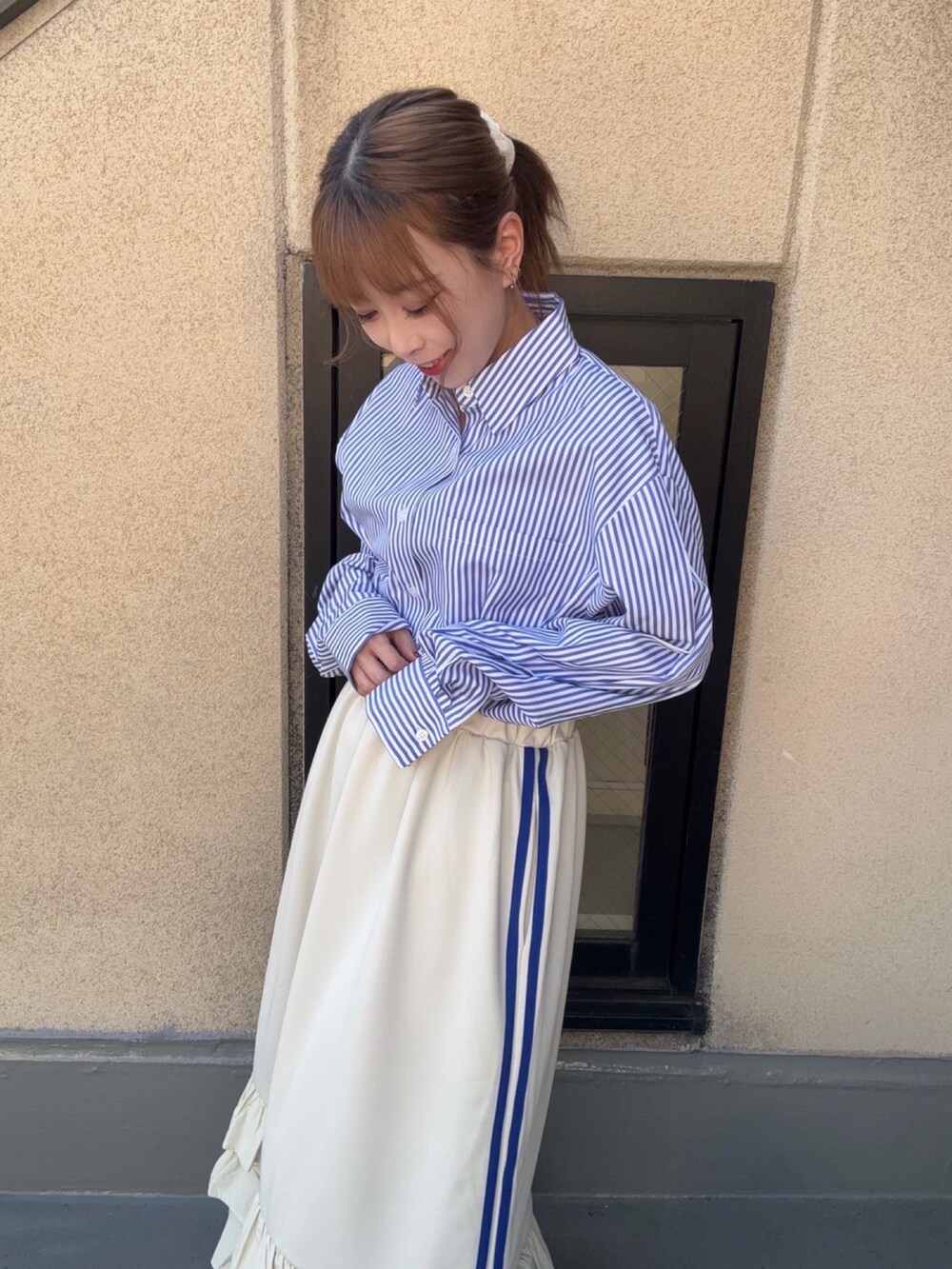 ホワイト系のスカート、ブルー系のシャツ/ブラウスを着用したレディースの春コーディネートの3枚目の写真