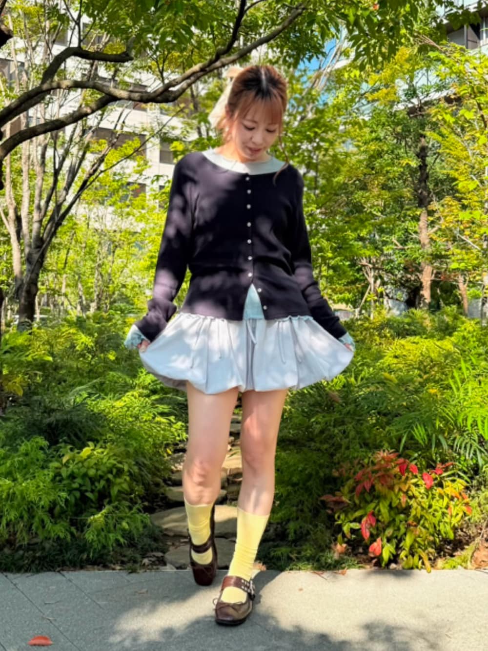 グレー系のスカート、ブルー系のTシャツ/カットソー、ブルー系のカーディガン/ボレロを着用したレディースの秋コーディネートの7枚目の写真