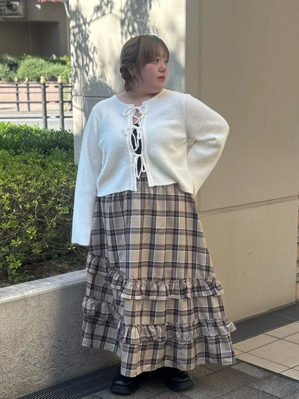 ベージュ系のスカート、ホワイト系のカーディガン/ボレロを着用したレディースの秋コーディネートの2枚目の写真
