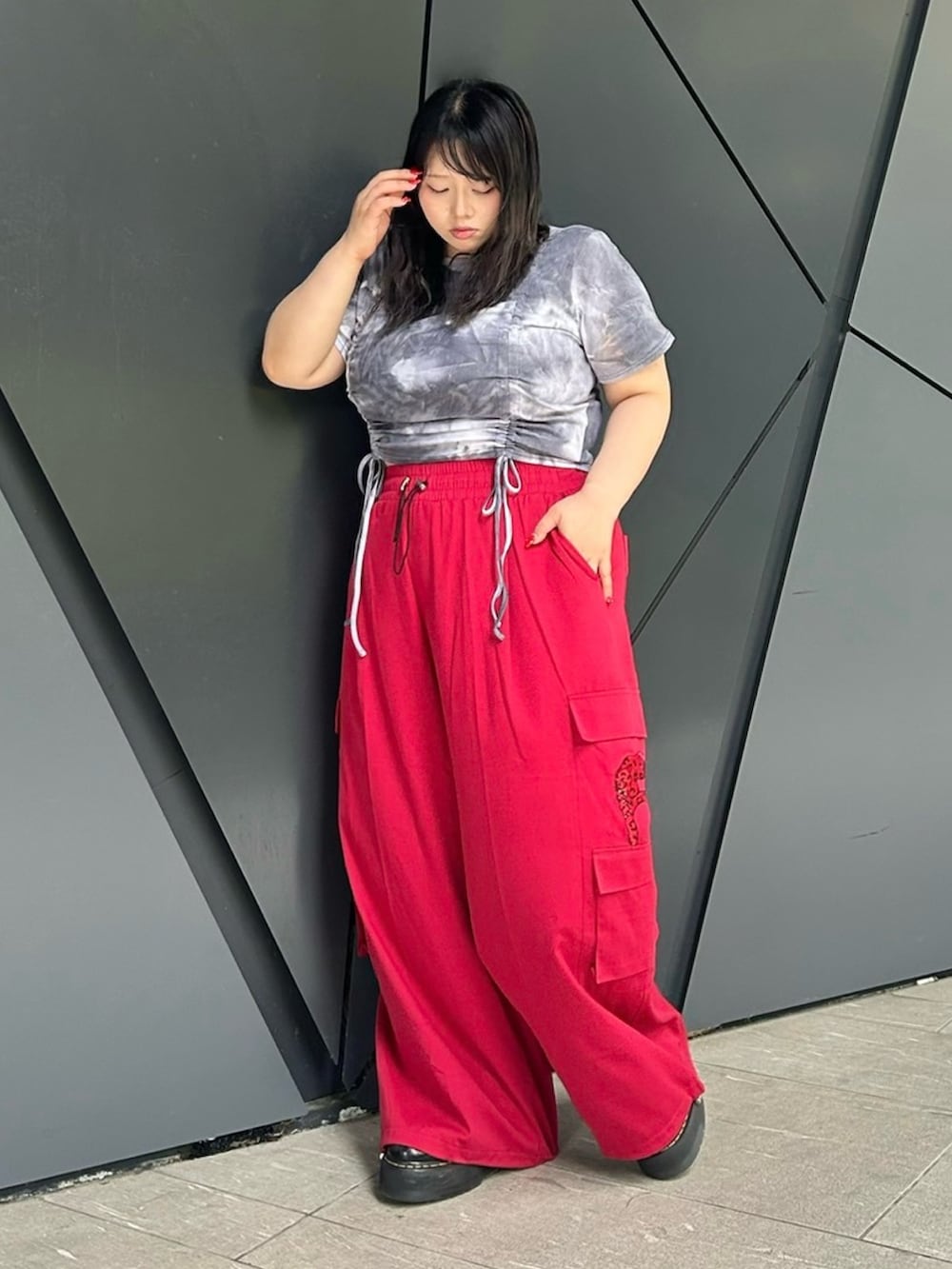 レッド系のカーゴパンツ、ブラック系のTシャツ/カットソーを着用したレディースの夏コーディネートの2枚目の写真