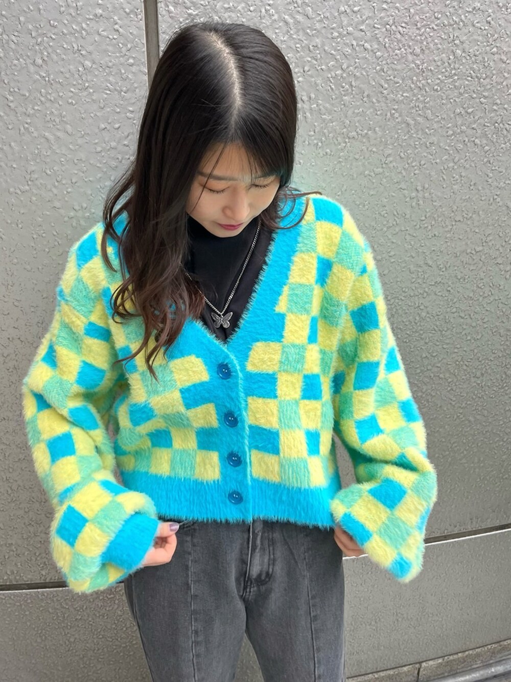 ブラック系のデニムパンツ、ブルー系のカーディガン/ボレロ、ブラック系のTシャツ/カットソーを着用したレディースの冬コーディネートの3枚目の写真