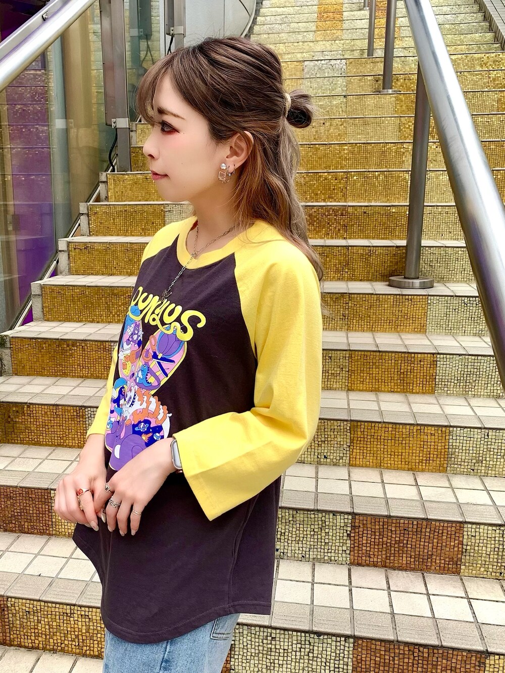 ブルー系のデニムパンツ、ブラック系のサンダル、イエロー系のTシャツ/カットソーを着用したレディースの夏コーディネートの2枚目の写真