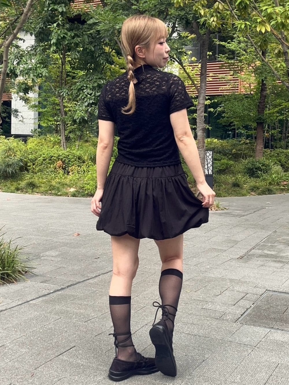 ブラック系のスカート、ブラック系のTシャツ/カットソーを着用したレディースの夏コーディネートの6枚目の写真
