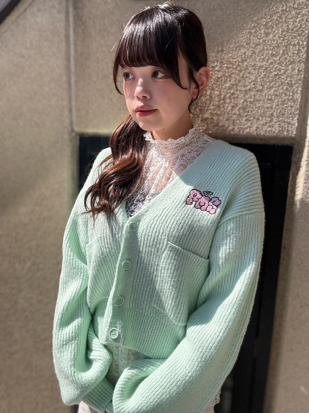 ホワイト系のスカート、ホワイト系のTシャツ/カットソー、グリーン系のカーディガン/ボレロを着用したレディースの春コーディネートの5枚目の写真