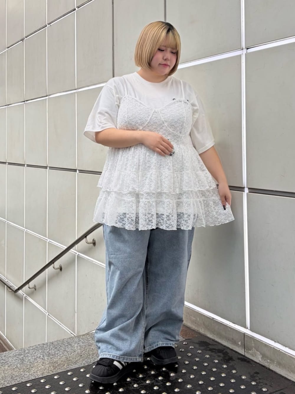 ブルー系のデニムパンツ、ホワイト系のワンピース、ブラック系のブルゾンを着用したレディースの春コーディネートの4枚目の写真