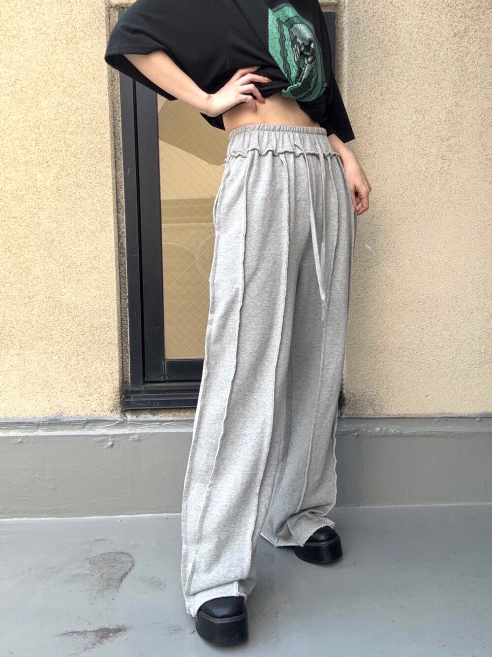 ブラック系のTシャツ/カットソー、グレー系のスウェットパンツを着用したレディースの秋コーディネートの2枚目の写真