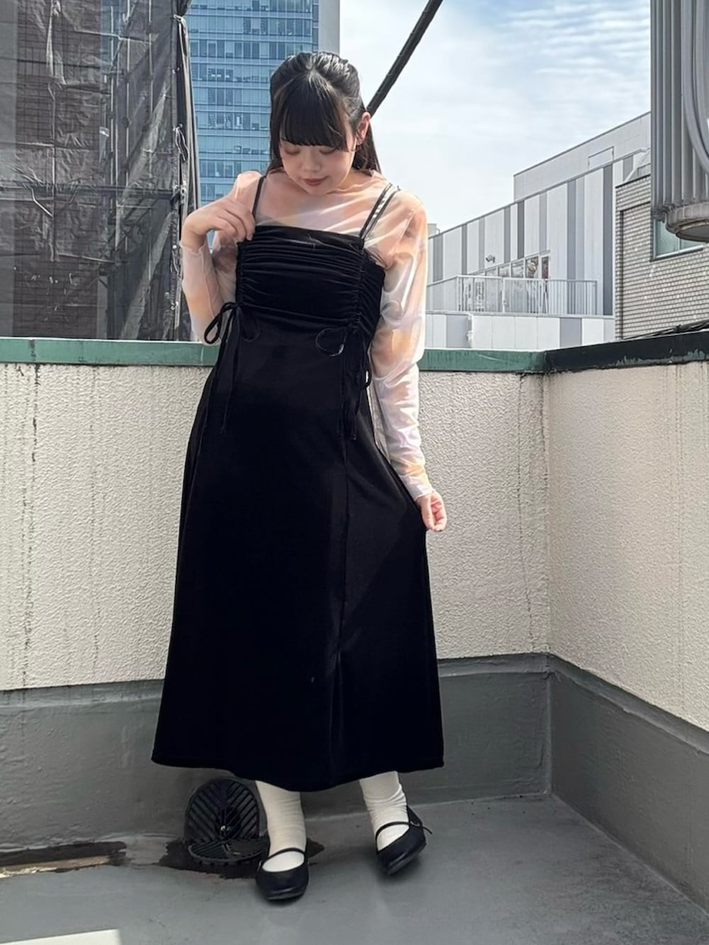 ブラック系のワンピース、オレンジ系のTシャツ/カットソーを着用したレディースの春コーディネートの2枚目の写真