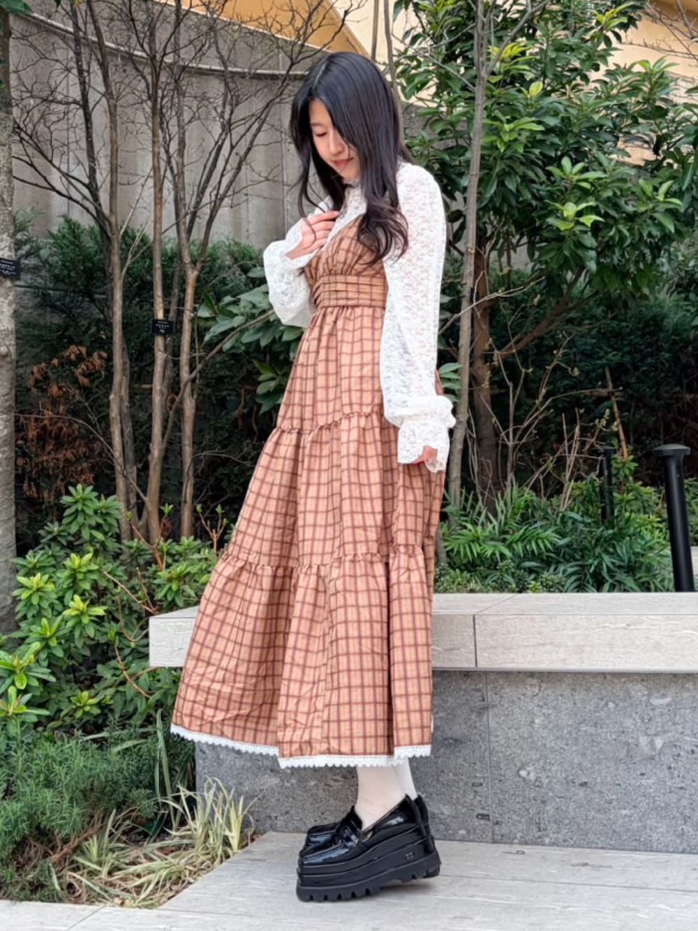 ブラウン系のワンピース、ホワイト系のTシャツ/カットソーを着用したレディースの春コーディネートの2枚目の写真