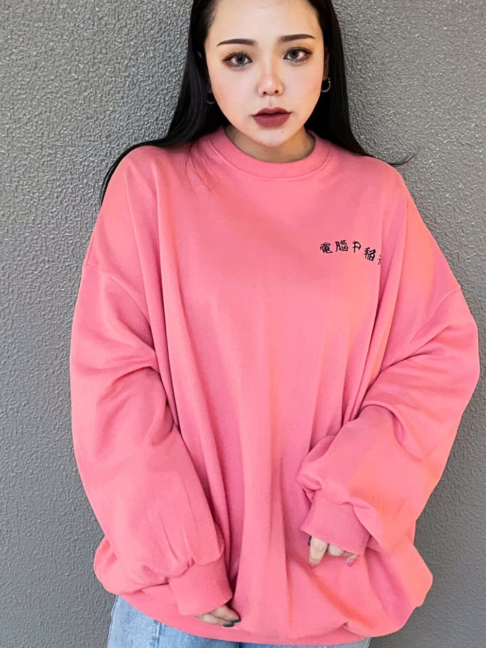 ブルー系のデニムパンツ、ピンク系のスウェットを着用したレディースの春コーディネートの3枚目の写真