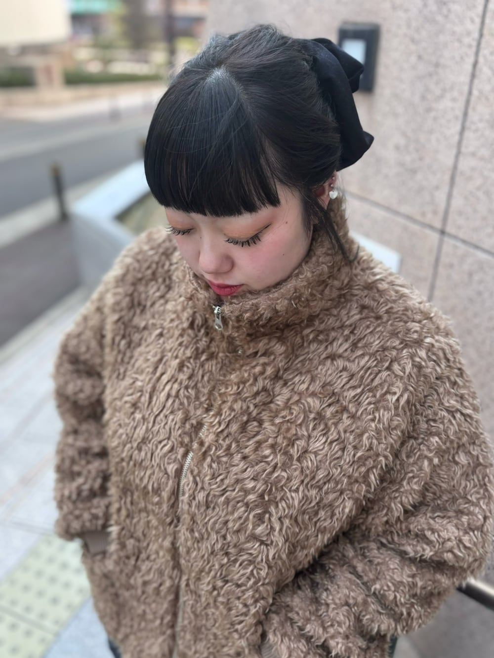 ブラック系のデニムパンツ、ブラック系のデニムスカート、ブラウン系のブルゾンを着用したレディースの冬コーディネートの3枚目の写真