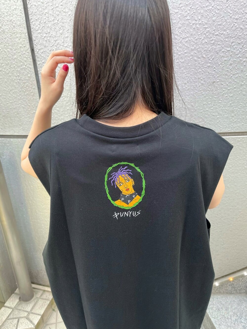 パープル系のデニムパンツ、ブラック系のTシャツ/カットソー、ブラック系のスニーカーを着用したレディースの春コーディネートの3枚目の写真