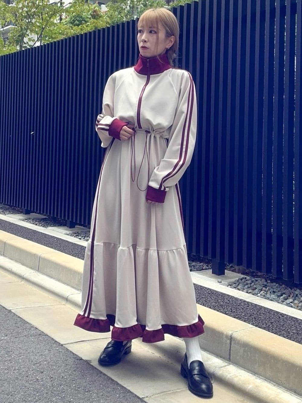 ベージュ系のワンピースを着用したレディースの秋コーディネートの2枚目の写真