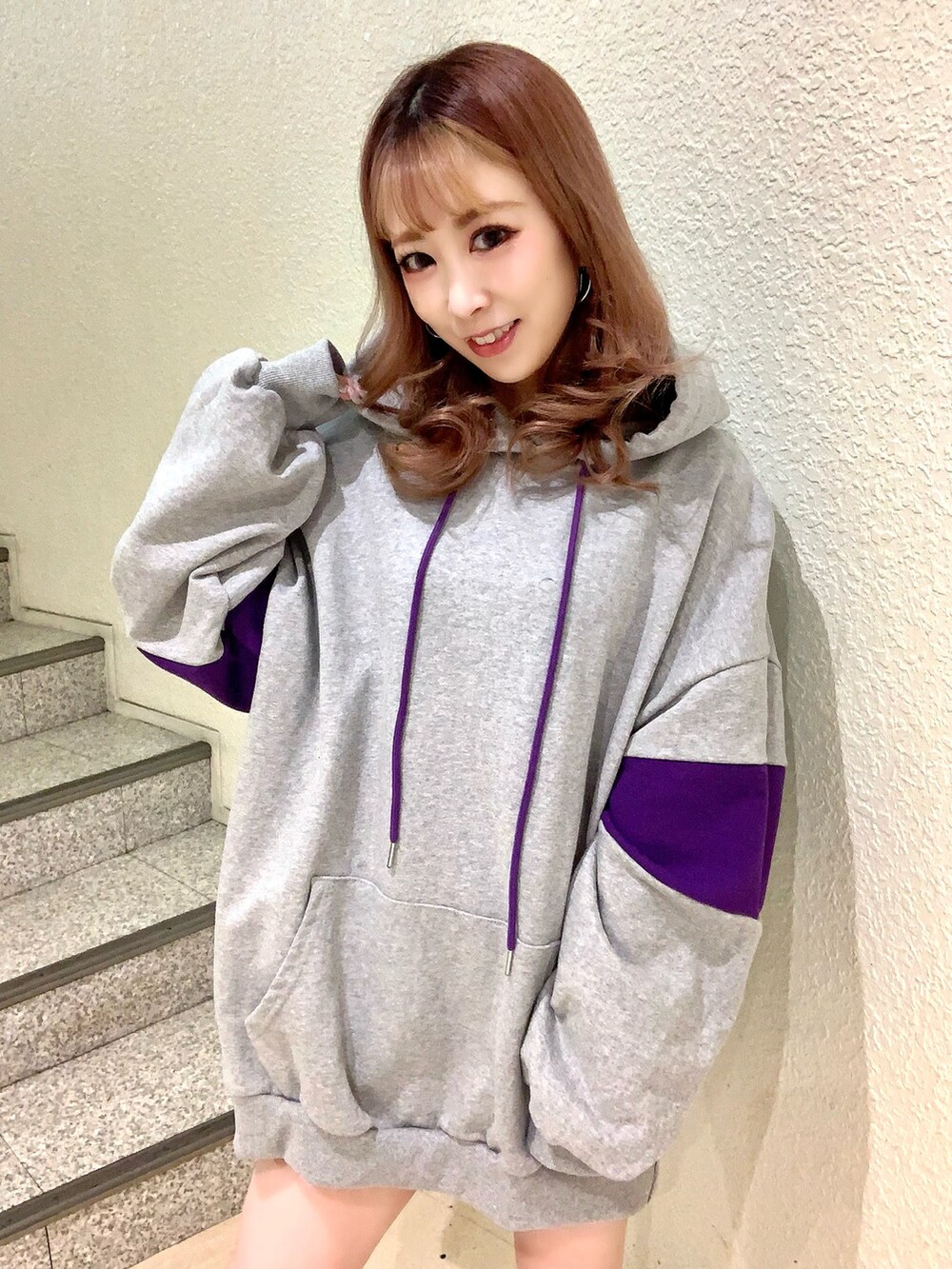 グレー系のパーカー、ブルー系のデニムジャケット、ブラック系のブーツを着用したレディースの冬コーディネートの4枚目の写真