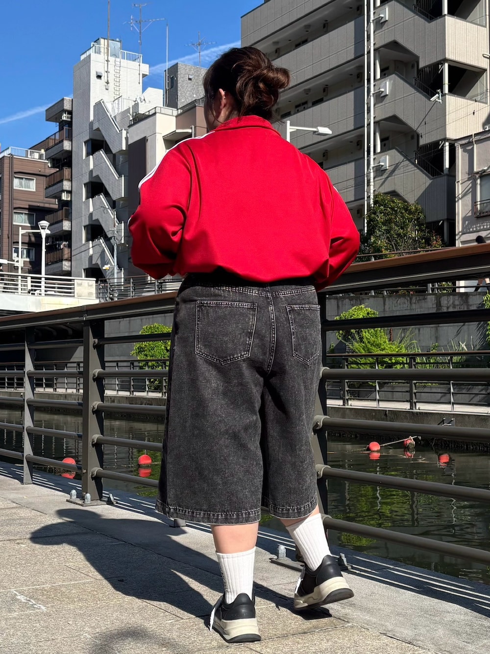 ブラック系のデニムパンツ、レッド系のジャージを着用したレディースの夏コーディネートの5枚目の写真