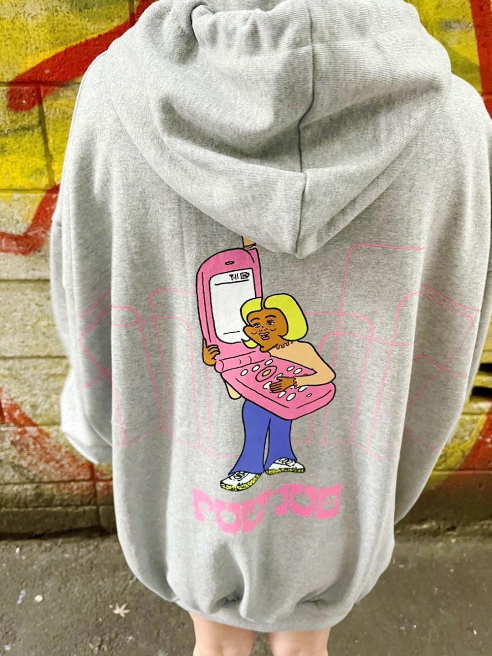 グレー系のパーカー、ホワイト系のスニーカーを着用したレディースの春コーディネートの2枚目の写真