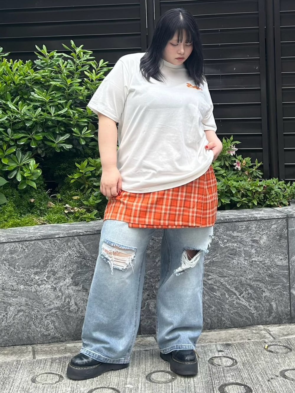 ブルー系のデニムパンツ、オレンジ系のスカート、ホワイト系のTシャツ/カットソーを着用したレディースの春コーディネートの2枚目の写真