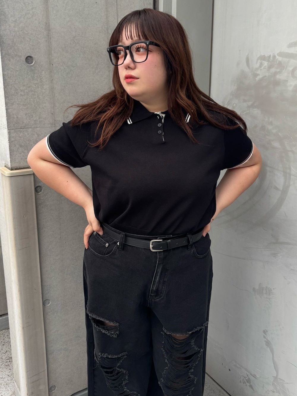 ブラック系のデニムパンツ、ブラック系のポロシャツ、ブラック系のベルトを着用したレディースの夏コーディネートの3枚目の写真