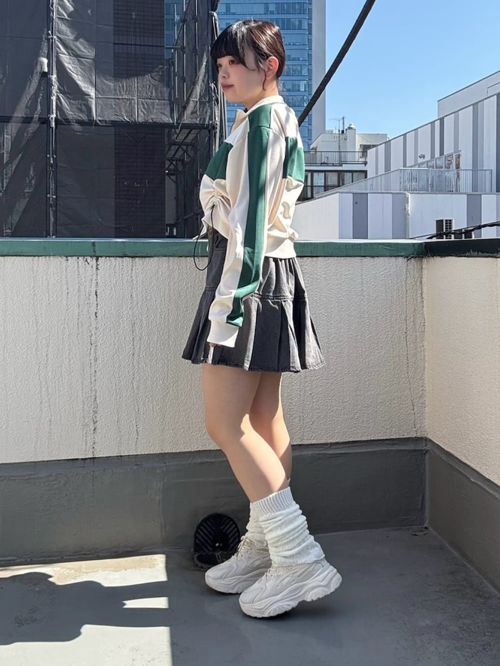 ブラック系のデニムスカート、ホワイト系のジャージを着用したレディースの春コーディネートの3枚目の写真