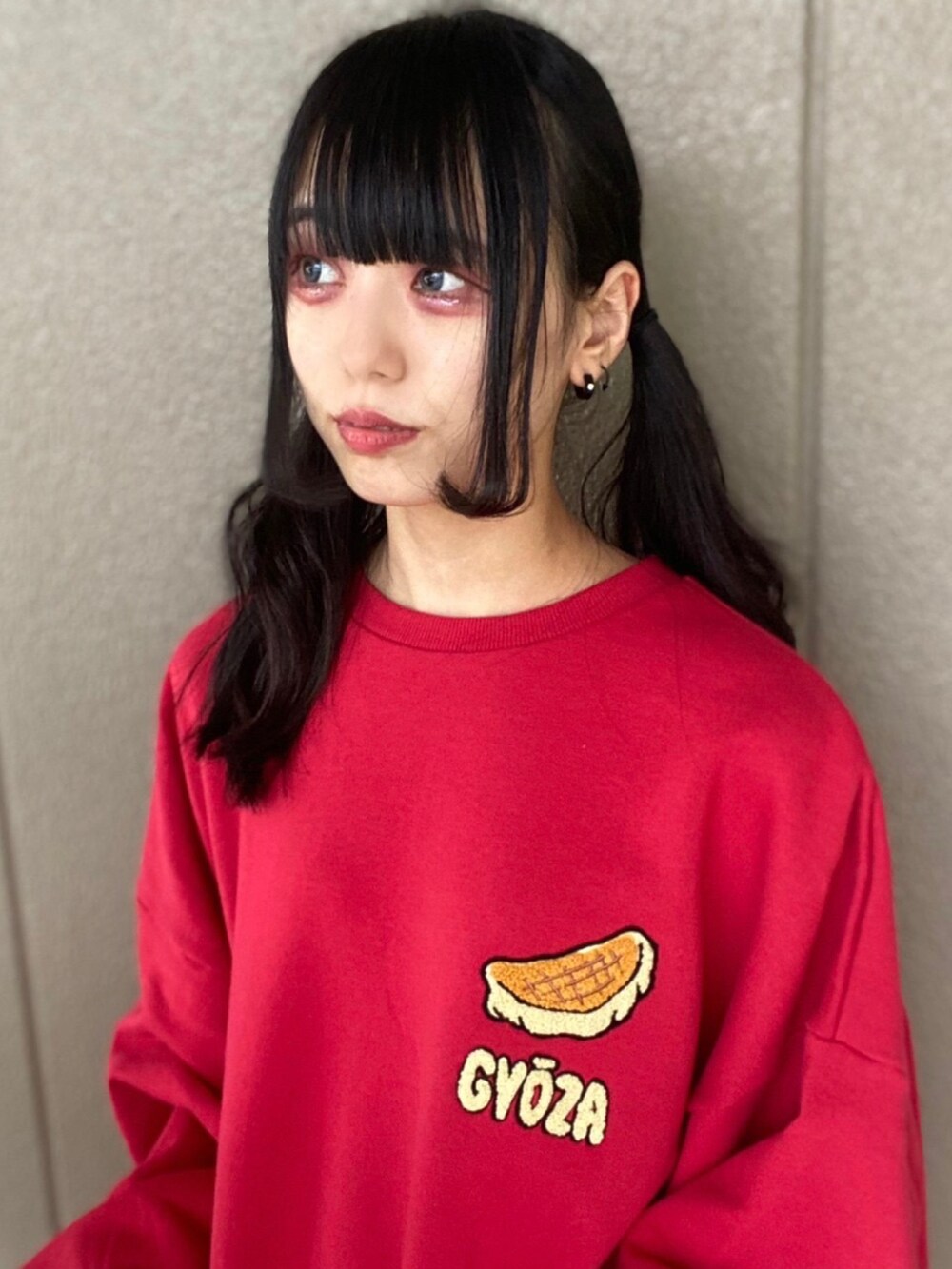 レッド系のスウェット、ブラック系のブーツを着用したレディースの秋コーディネートの3枚目の写真