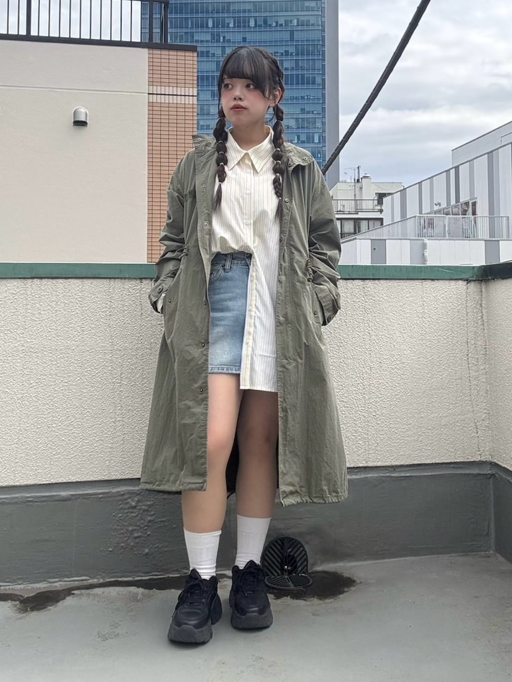 イエロー系のシャツ/ブラウス、グリーン系のモッズコート、ブルー系のデニムスカートを着用したレディースの春コーディネートの2枚目の写真