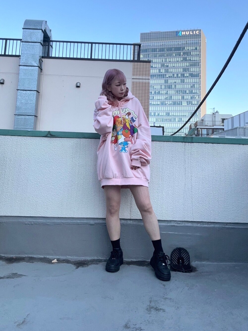 グリーン系のナイロンジャケット、ピンク系のパーカーを着用したレディースの冬コーディネートの3枚目の写真