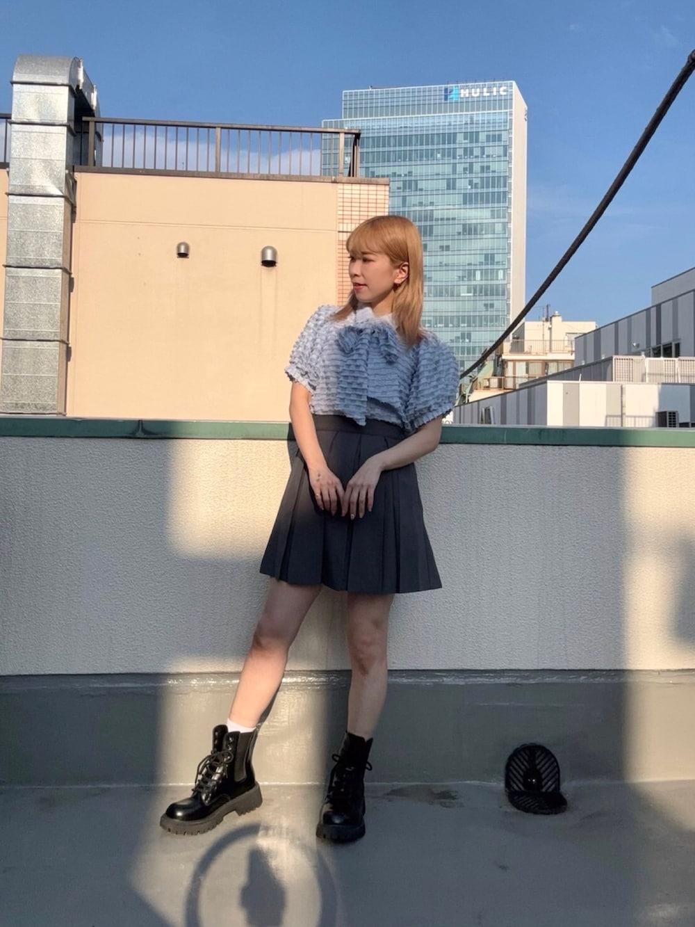 ブルー系のシャツ/ブラウス、グレー系のスカートを着用したレディースの夏コーディネートの2枚目の写真