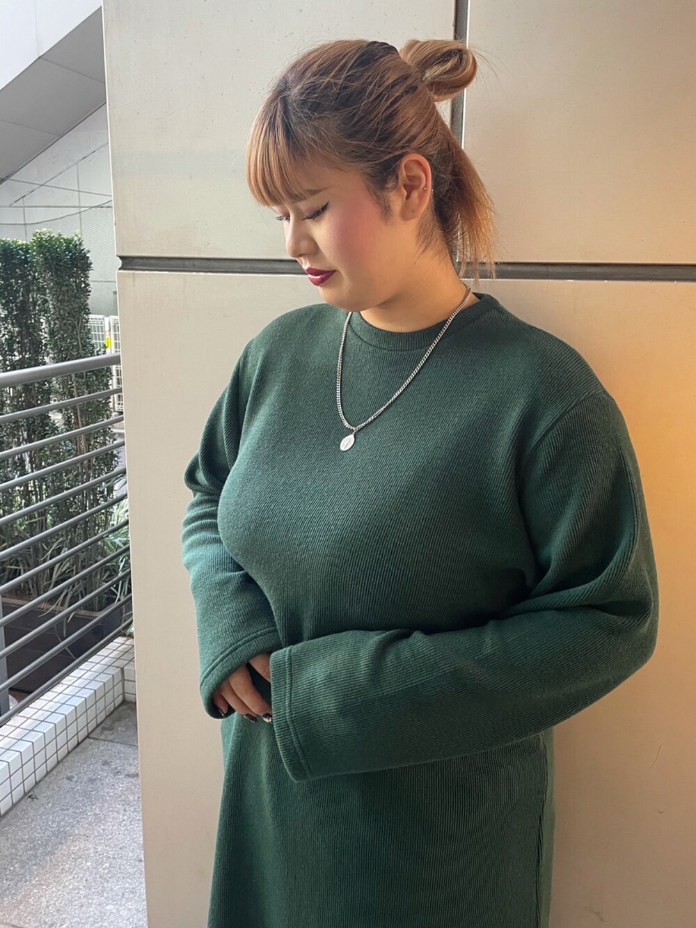 グリーン系のワンピース、ブルー系のデニムパンツを着用したレディースの秋コーディネートの3枚目の写真