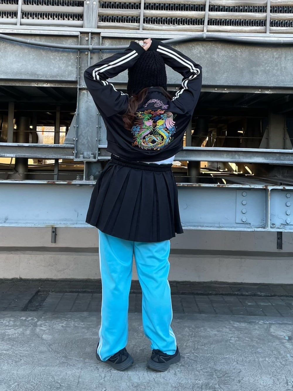 ブラック系のジャージ、ブラック系のスカート、ブルー系のその他パンツを着用したレディースの冬コーディネートの3枚目の写真