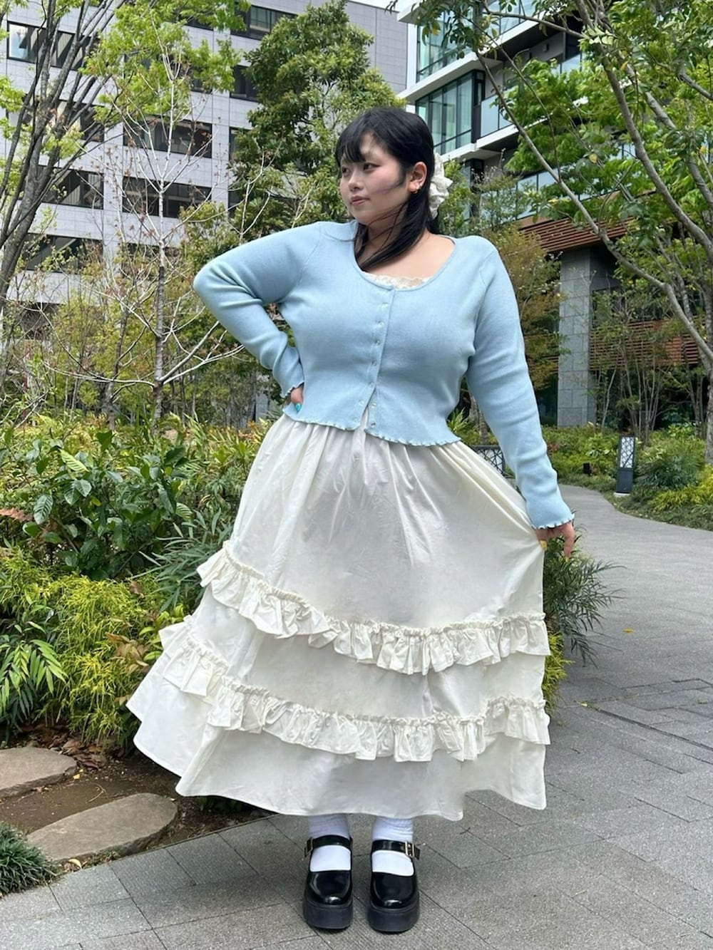 ホワイト系のスカート、ブルー系のカーディガン/ボレロを着用したレディースの春コーディネートの2枚目の写真