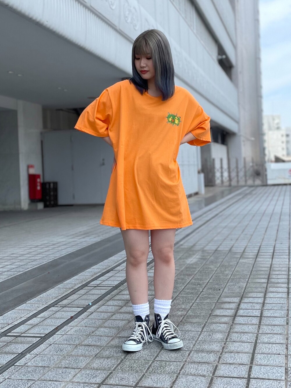 オレンジ系のTシャツ/カットソーを着用したレディースの夏コーディネートの2枚目の写真