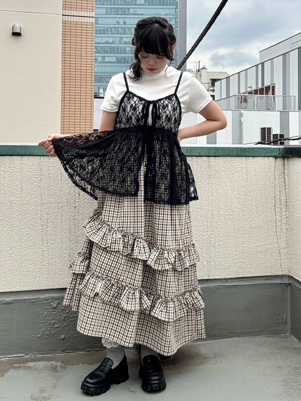 ベージュ系のスカート、ブラック系のチュニック、ホワイト系のTシャツ/カットソーを着用したレディースの夏コーディネートの3枚目の写真