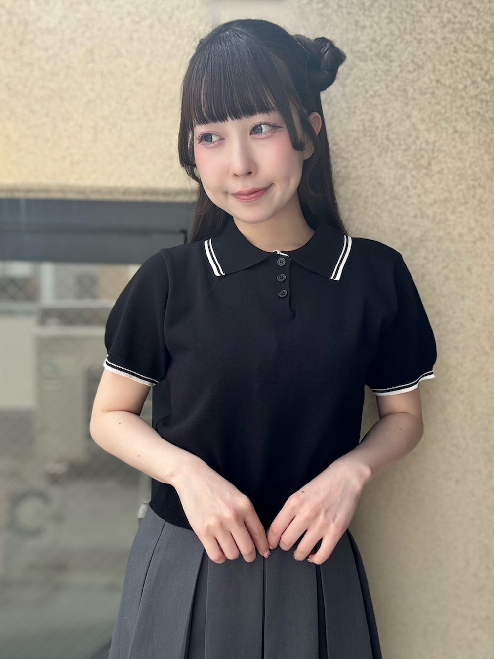 グレー系のスカート、ブラック系のポロシャツを着用したレディースの夏コーディネートの5枚目の写真