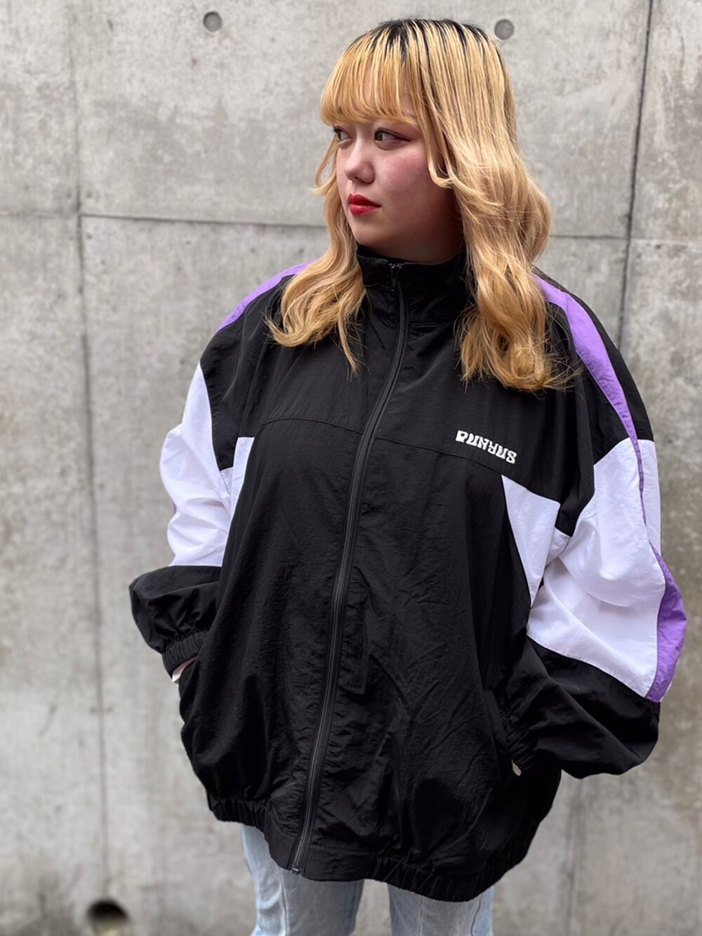 ブルー系のデニムパンツ、ブラック系のナイロンジャケットを着用したレディースの春コーディネートの2枚目の写真