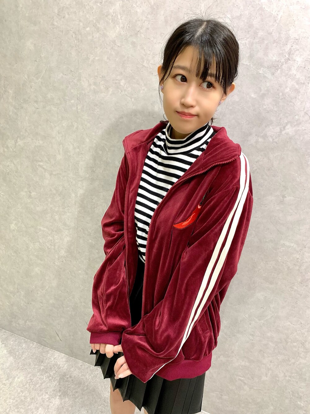 ブラック系のスカート、ホワイト系のTシャツ/カットソー、レッド系のジャージを着用したレディースの秋コーディネートの2枚目の写真