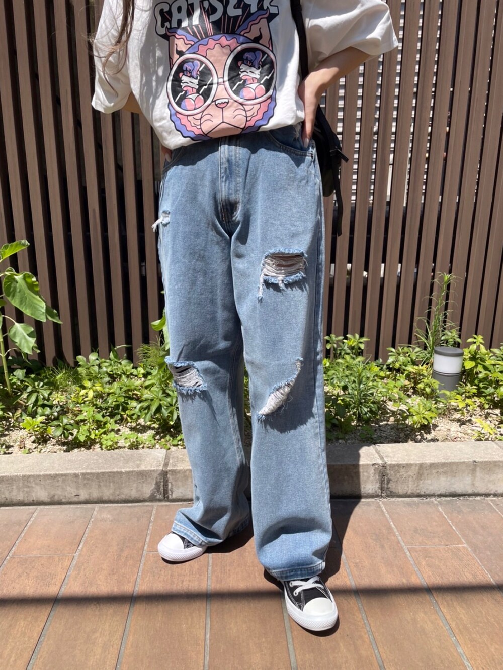 ブルー系のデニムパンツ、グレー系のTシャツ/カットソー、ブラック系のショルダーバッグを着用したレディースの夏コーディネートの2枚目の写真