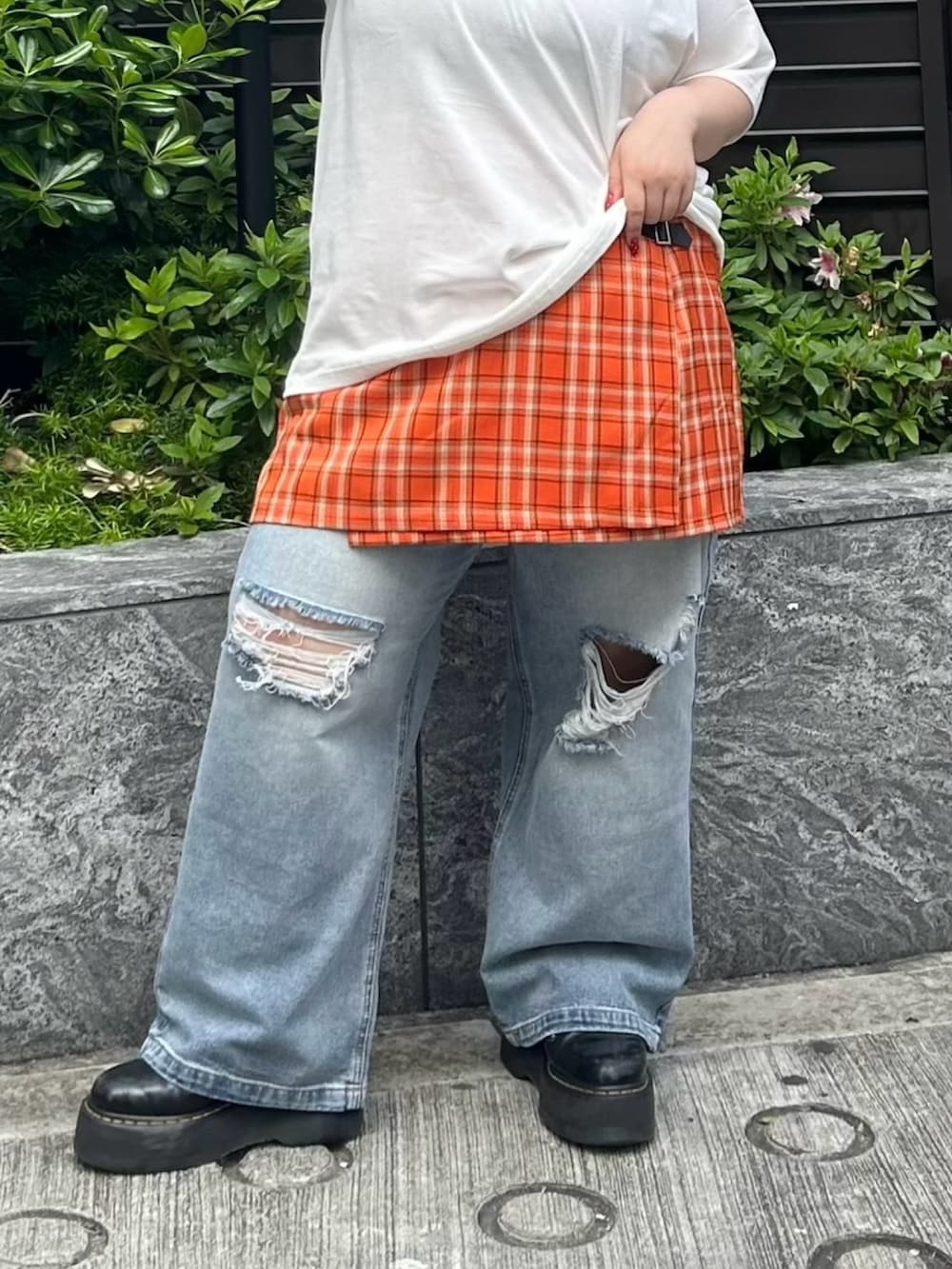 ブルー系のデニムパンツ、オレンジ系のスカート、ホワイト系のTシャツ/カットソーを着用したレディースの春コーディネートの6枚目の写真