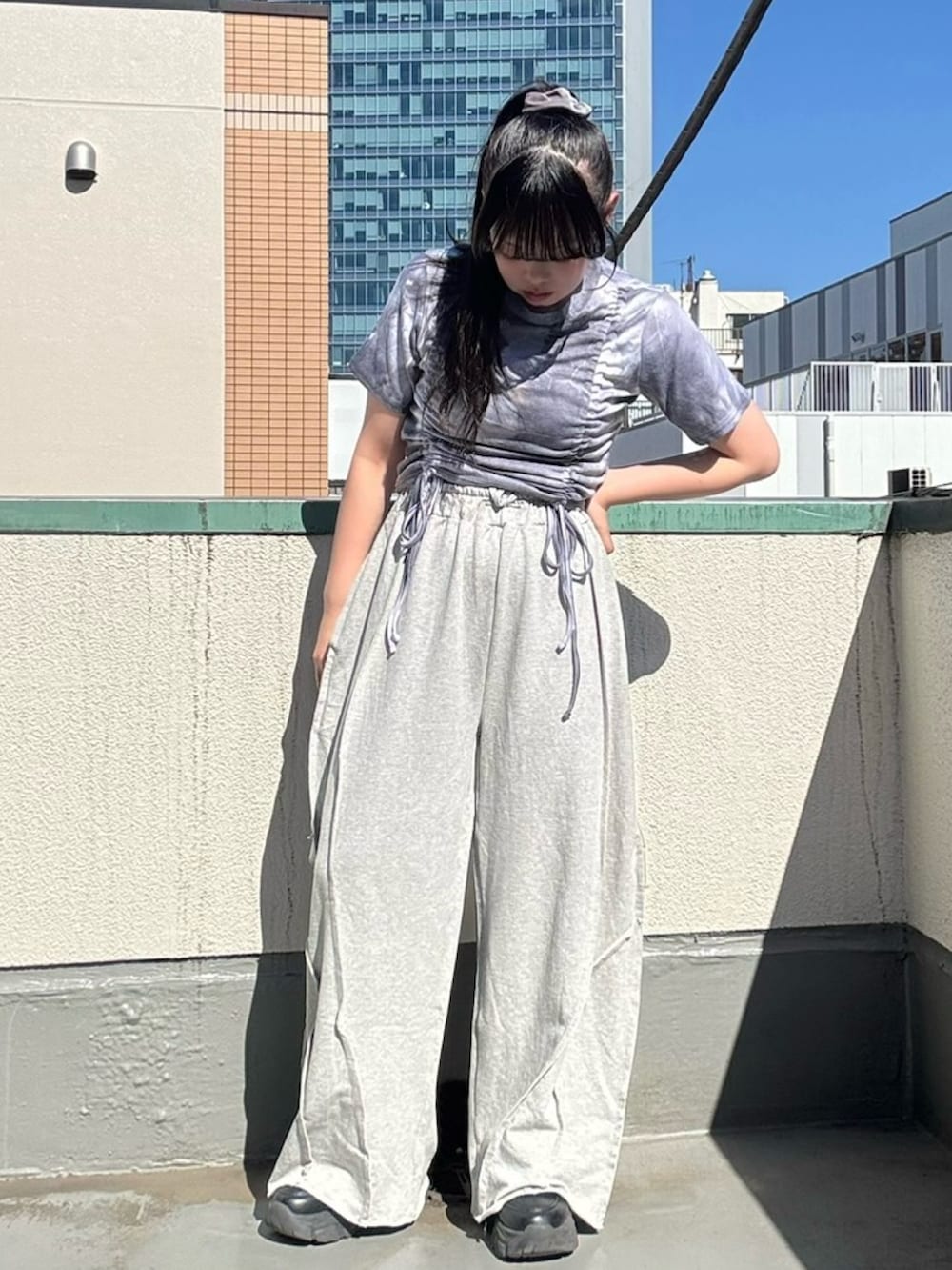 グレー系のスウェットパンツ、パープル系のTシャツ/カットソーを着用したレディースの夏コーディネートの4枚目の写真