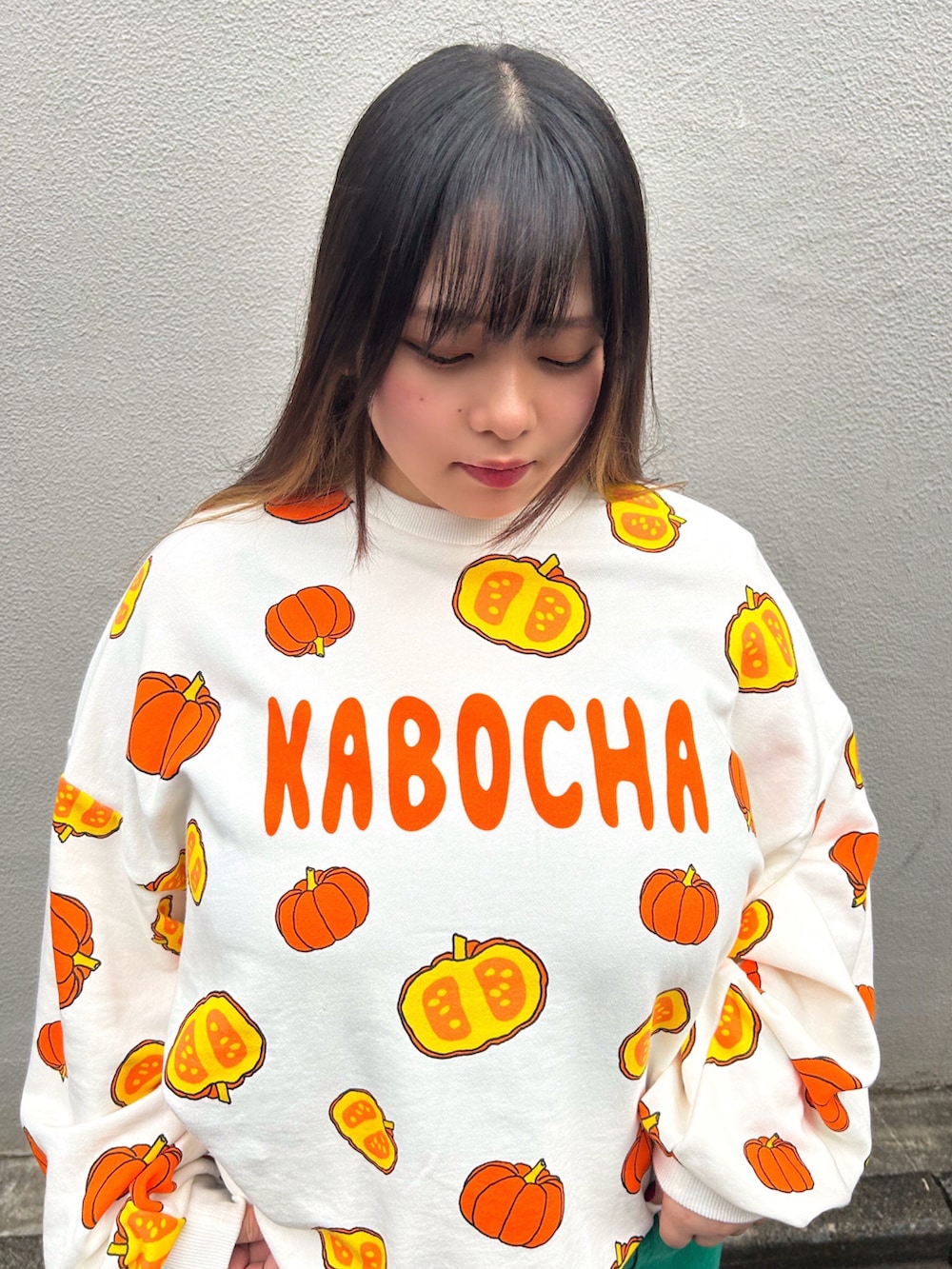 グリーン系のその他パンツ、オレンジ系のスウェットを着用したレディースの秋コーディネートの2枚目の写真