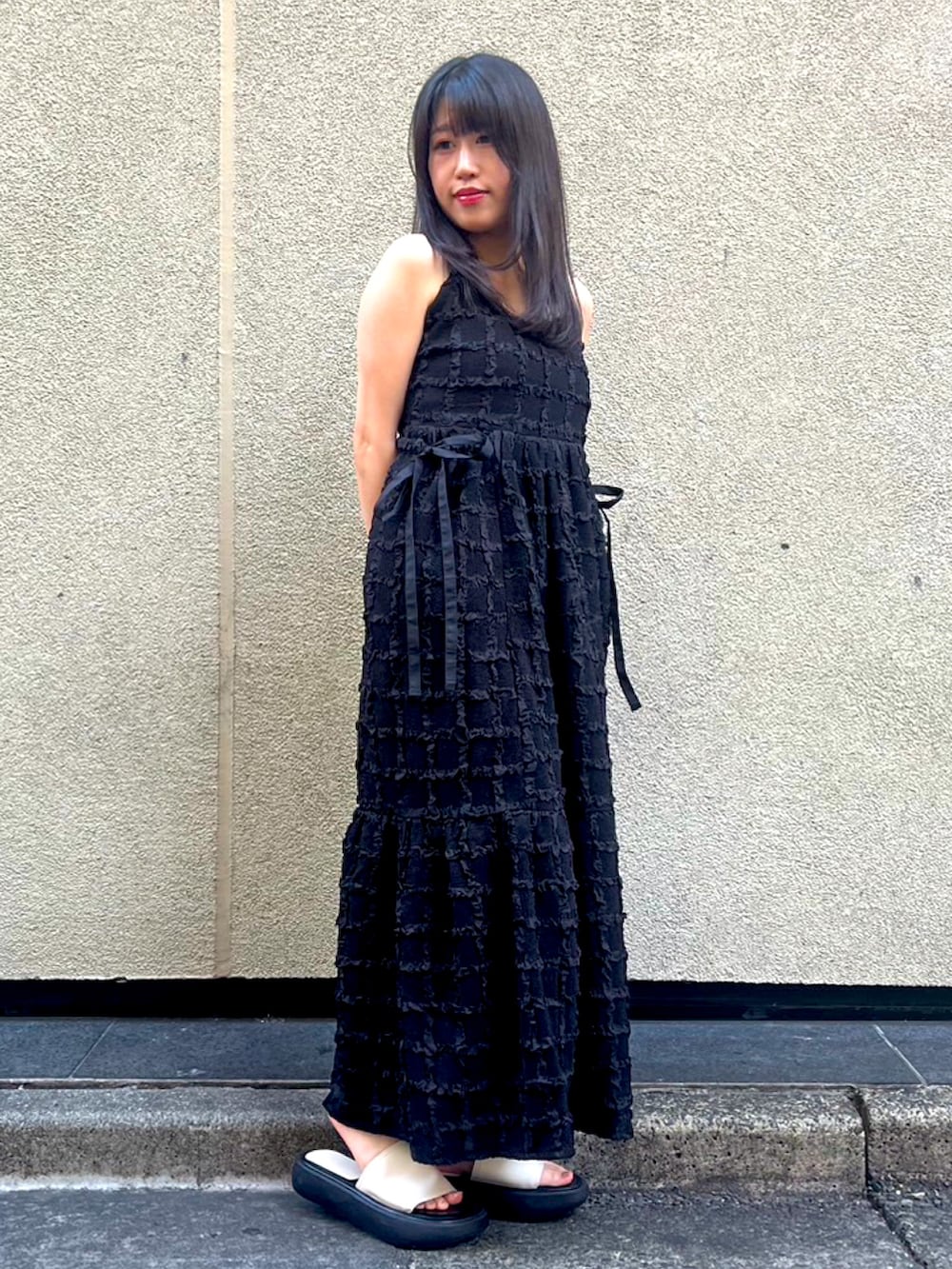 ブラック系のワンピースを着用したレディースの夏コーディネートの2枚目の写真