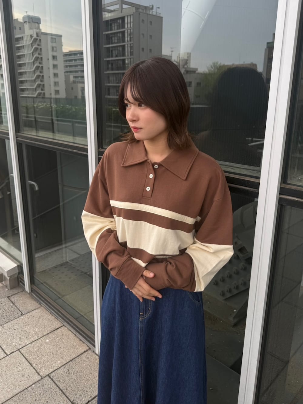 ブルー系のスカート、ブラウン系のスウェットを着用したレディースの春コーディネートの2枚目の写真