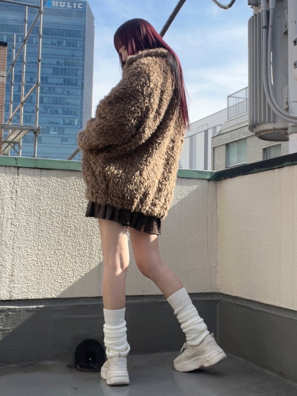 ブラウン系のブルゾン、ブラウン系のスカートを着用したレディースの冬コーディネートの4枚目の写真