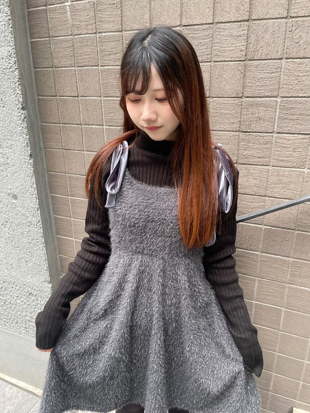 グレー系のワンピース、ブラック系のニット/セーターを着用したレディースの冬コーディネートの3枚目の写真