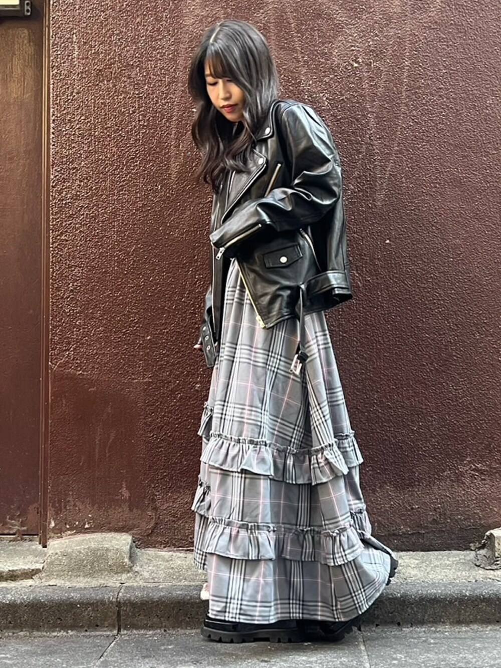 グレー系のスカート、ブラック系のライダースジャケットを着用したレディースの秋コーディネートの3枚目の写真