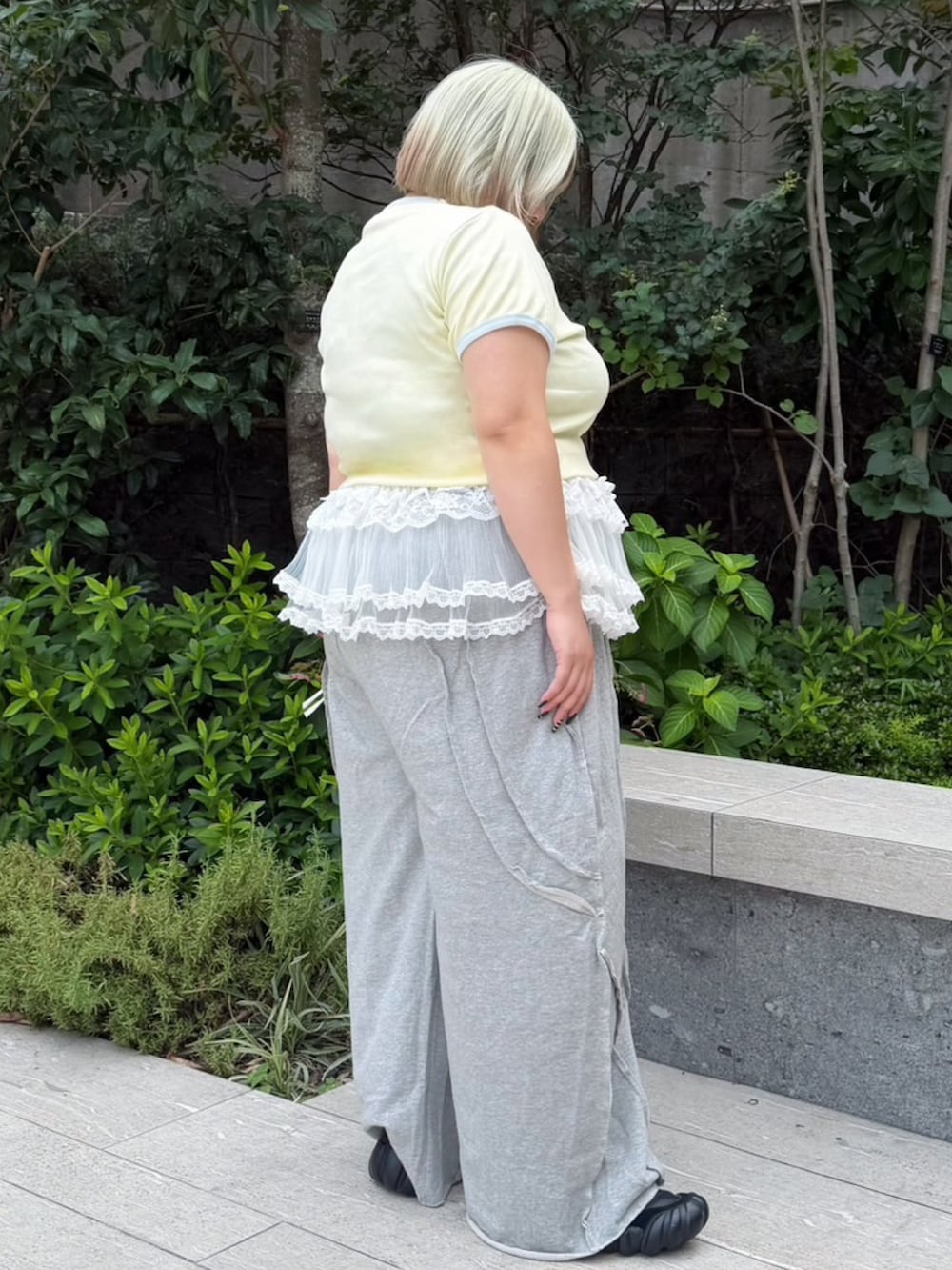 グレー系のスウェットパンツ、ホワイト系のスカート、イエロー系のTシャツ/カットソーを着用したレディースの夏コーディネートの3枚目の写真