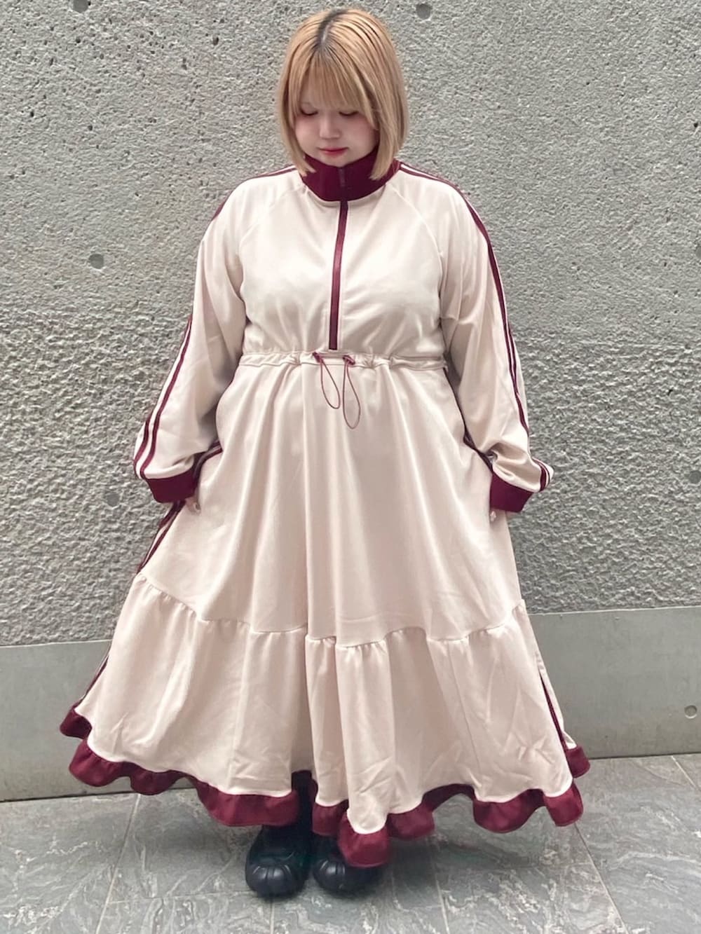 ベージュ系のワンピースを着用したレディースの秋コーディネートの2枚目の写真