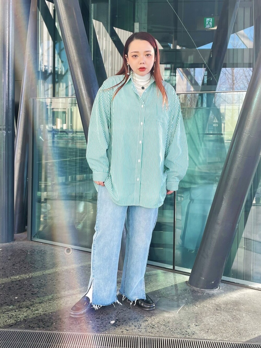 グリーン系のシャツ/ブラウス、ブルー系のデニムパンツ、ホワイト系のTシャツ/カットソーを着用したレディースの冬コーディネートの2枚目の写真