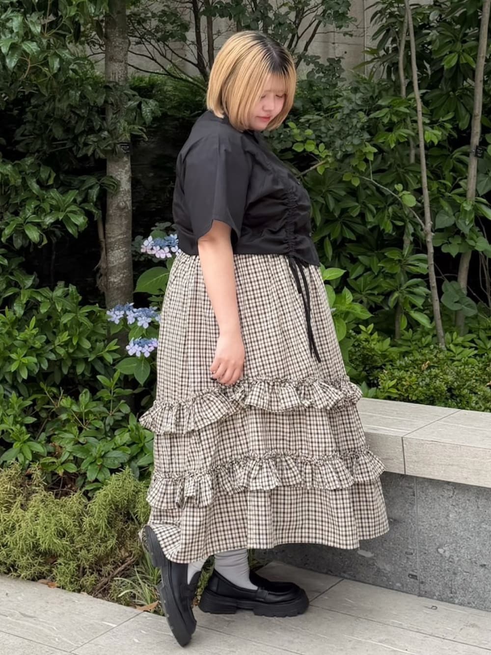 ベージュ系のスカート、ブラック系のシャツ/ブラウスを着用したレディースの夏コーディネートの3枚目の写真