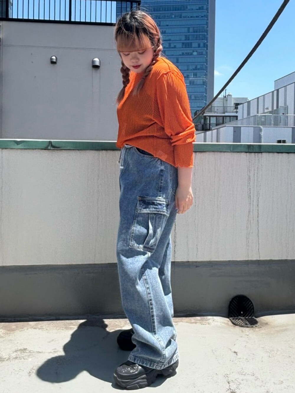 ブルー系のデニムパンツ、オレンジ系のTシャツ/カットソーを着用したレディースの夏コーディネートの3枚目の写真